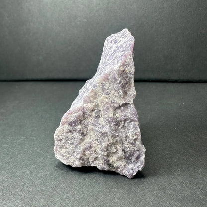 Rough purple lepidolite geode specimen with textured gray surface