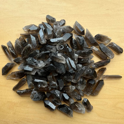 Pile of raw smoky quartz point crystals with brownish-gray hue