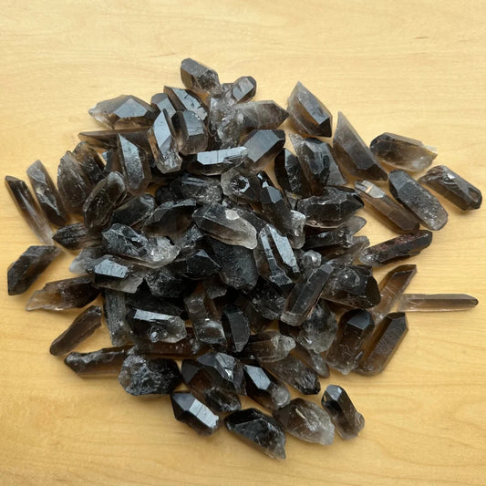 Pile of raw smoky quartz point crystals with brownish-gray hue