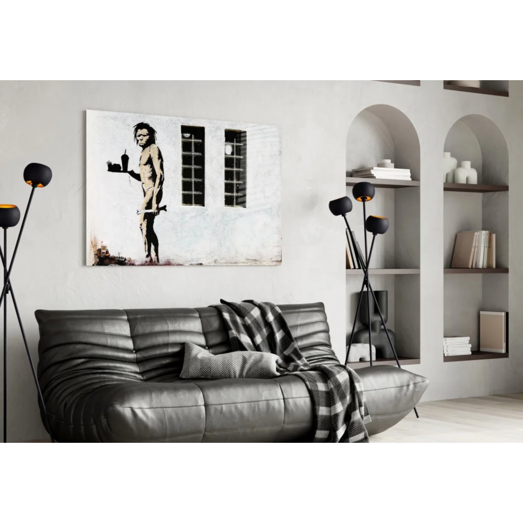 Black and white Banksy Evolution Ape wall art print on canvas above gray sofa