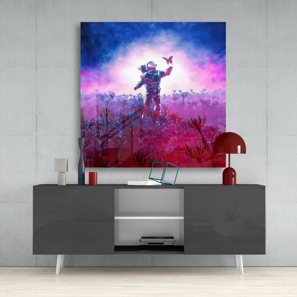 Astronaut in dark spacesuit holds red butterfly in neon pink purple glass wall art