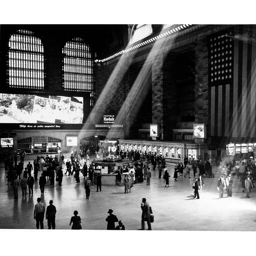 A large american flag hanging from the ceiling of a grand hudson river railroad train station for a river railroad gold bond certificate