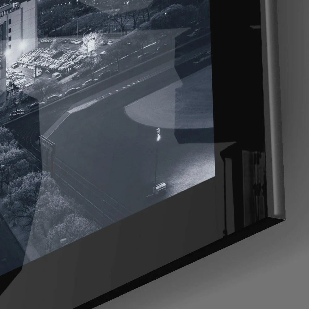 Black-framed monitor showing monochrome nighttime cityscape glass wall art