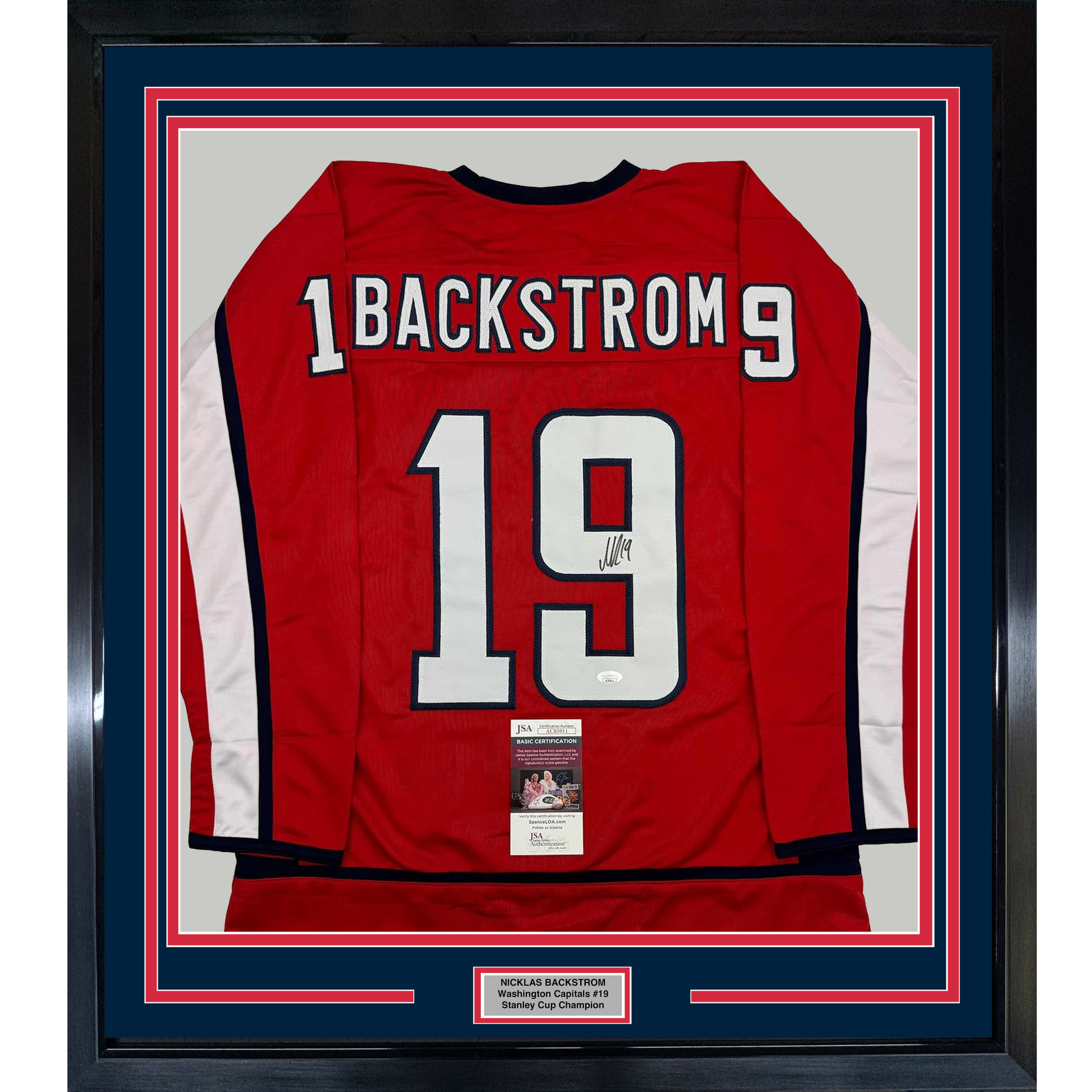 Red Washington Capitals hockey jersey number 19 with "BACKSTROM" nameplate, signed, displayed in framed matting with JSA certification label visible.
