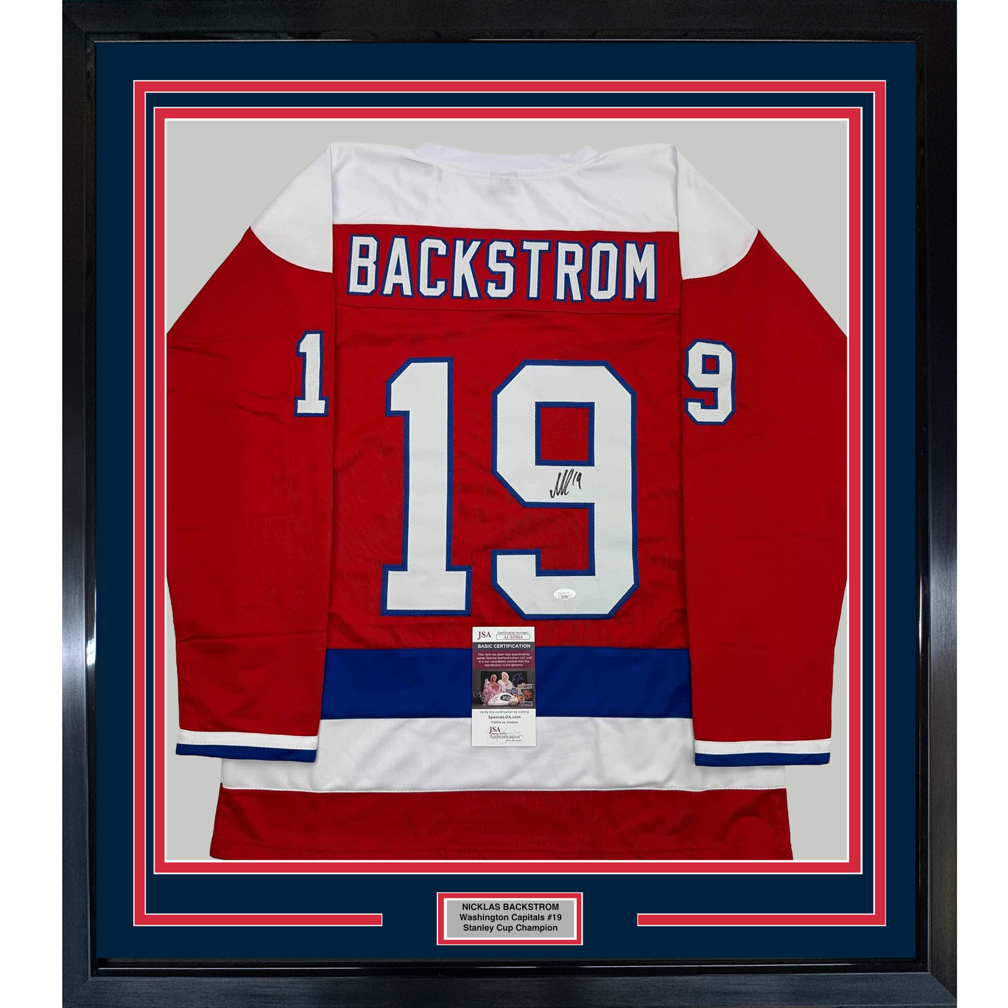 Framed red Washington Capitals hockey jersey number 19 with Backstrom nameplate, signed, displayed front-facing with authenticity certificates.