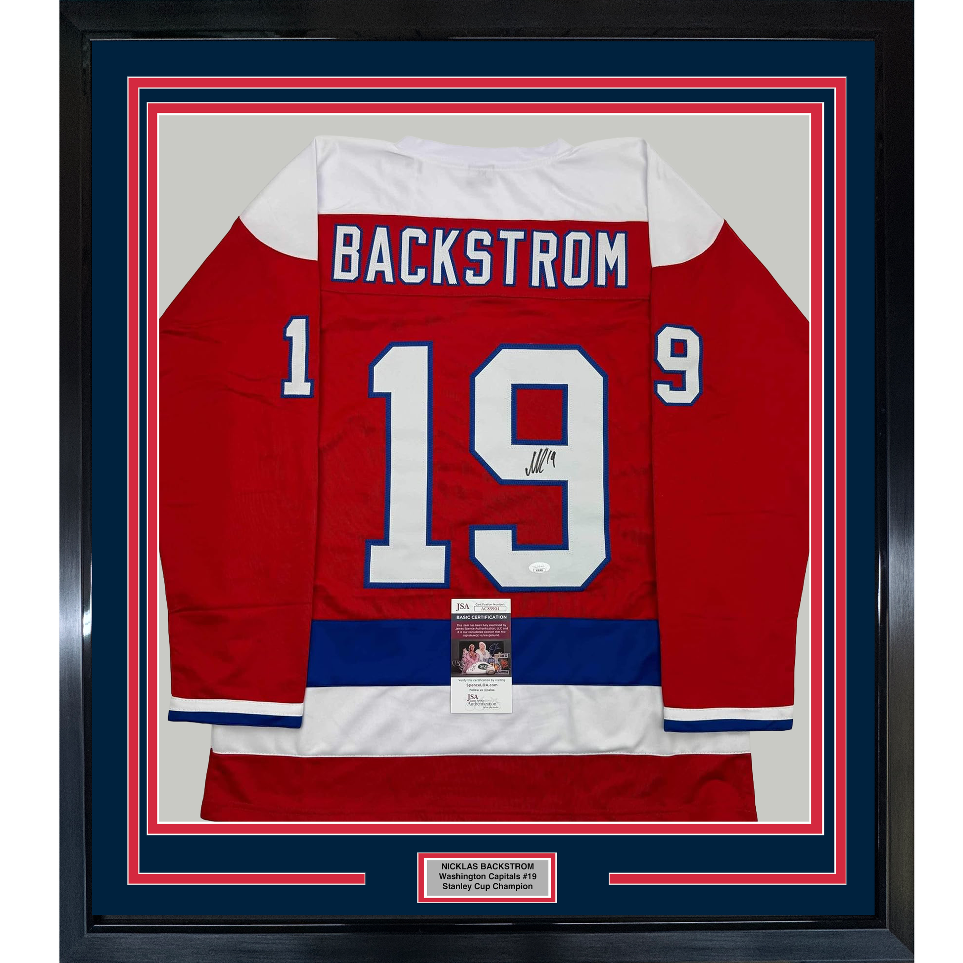 Framed red Washington Capitals hockey jersey number 19 with Backstrom nameplate, signed, displayed front-facing with authenticity certificates.