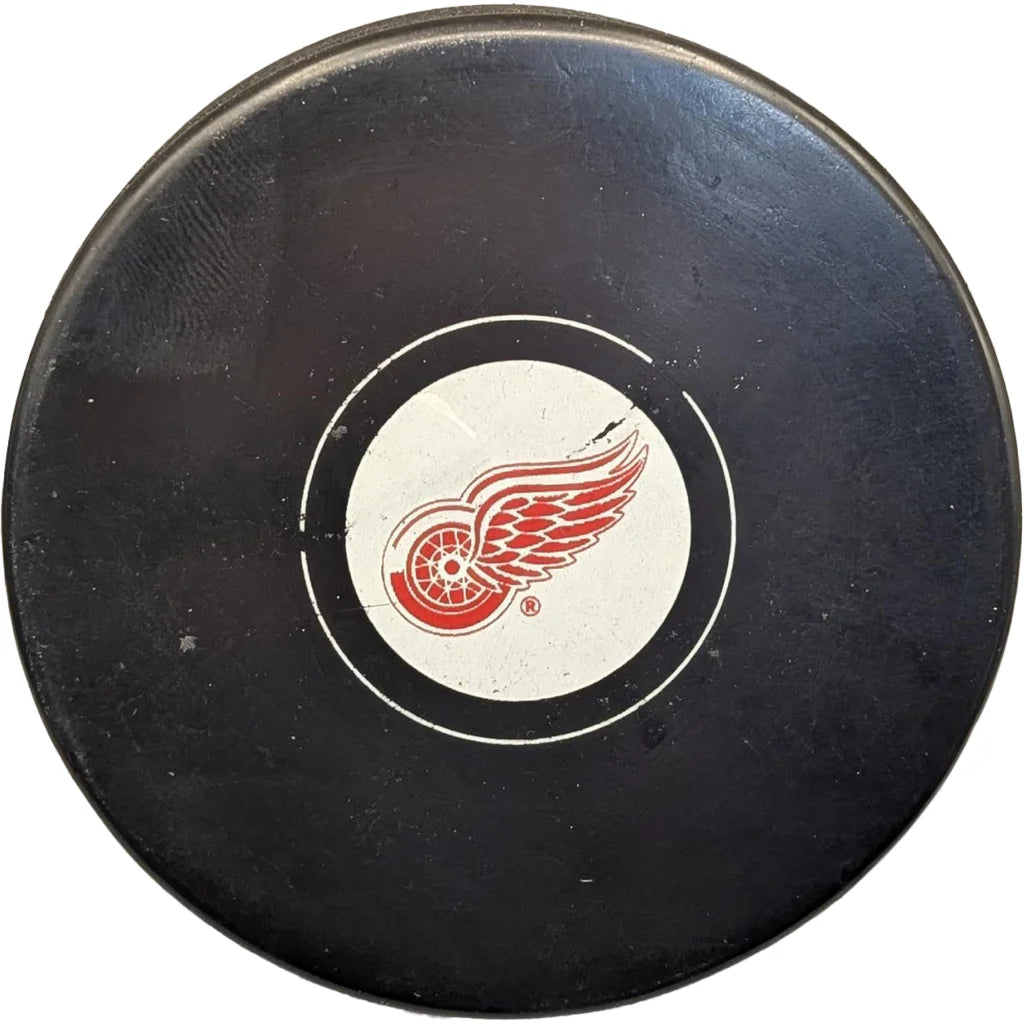 Official Detroit Red Wings licensed hockey puck with red white logo on black surface