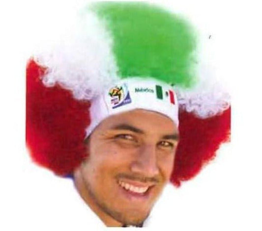 Man wearing red, white, and green afro wig with Mexican flag headband, smiling at camera.