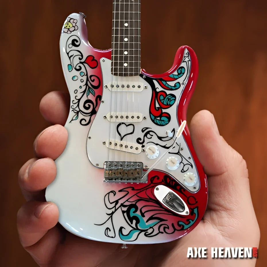 Mini white Axe Heaven® Jimi Hendrix guitar with floral design on stand