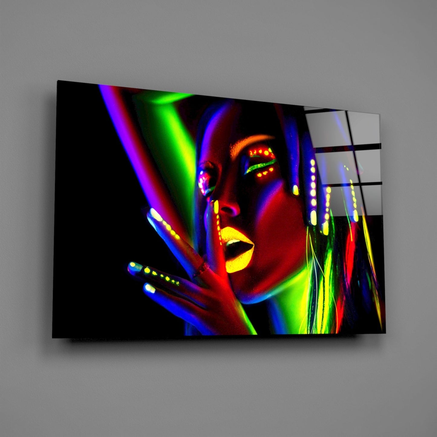 Neon-colored glass wall art displaying a woman's face in vibrant blues, greens, yellows, and reds against black background, mounted at an angle.