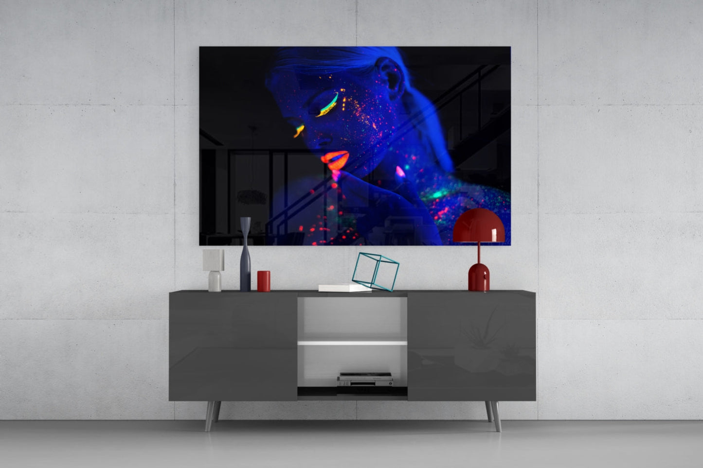 Modern living room setup featuring neon-glowing woman portrait glass art displayed above gray media console with red decorative accents.