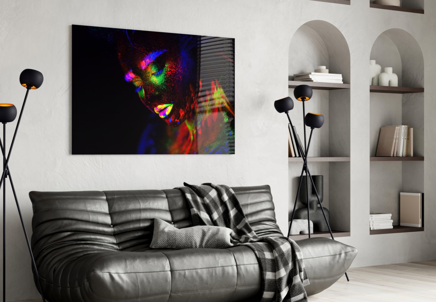 Colorful neon portrait of a woman's face displayed as glass wall art above a gray leather sofa in a modern living room.