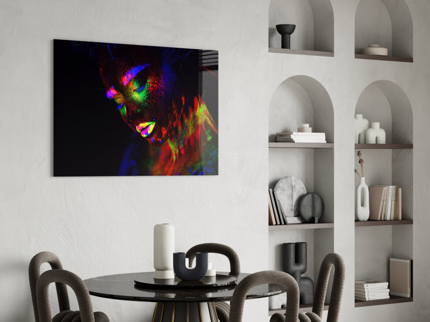 Vibrant glass wall art featuring a colorful neon portrait of a woman's face displayed above a black dining table in a modern interior.