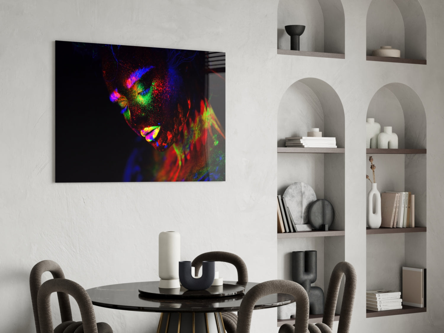 Vibrant glass wall art featuring a colorful neon portrait of a woman's face displayed above a black dining table in a modern interior.