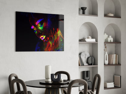 Vibrant glass wall art featuring a colorful neon portrait of a woman's face displayed above a black dining table in a modern interior.
