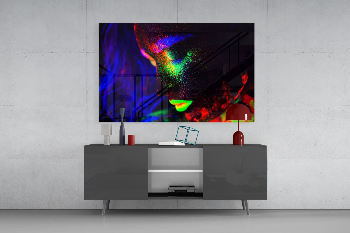 Vibrant abstract glass art with blue, red, green, and yellow colors displayed above a modern gray media console in a minimalist room setting.