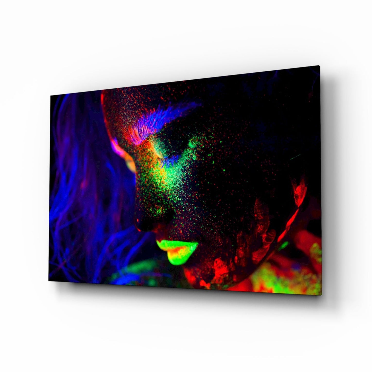 Colorful neon portrait on glass wall art displaying vibrant blue, red, green, and yellow fluorescent paint effects against black background.
