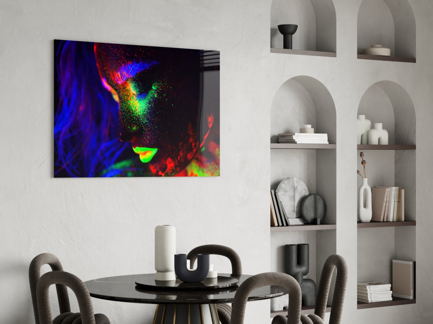 Vibrant neon-colored abstract portrait with blue, red, green, and yellow hues displayed as glass wall art above a modern dining table.