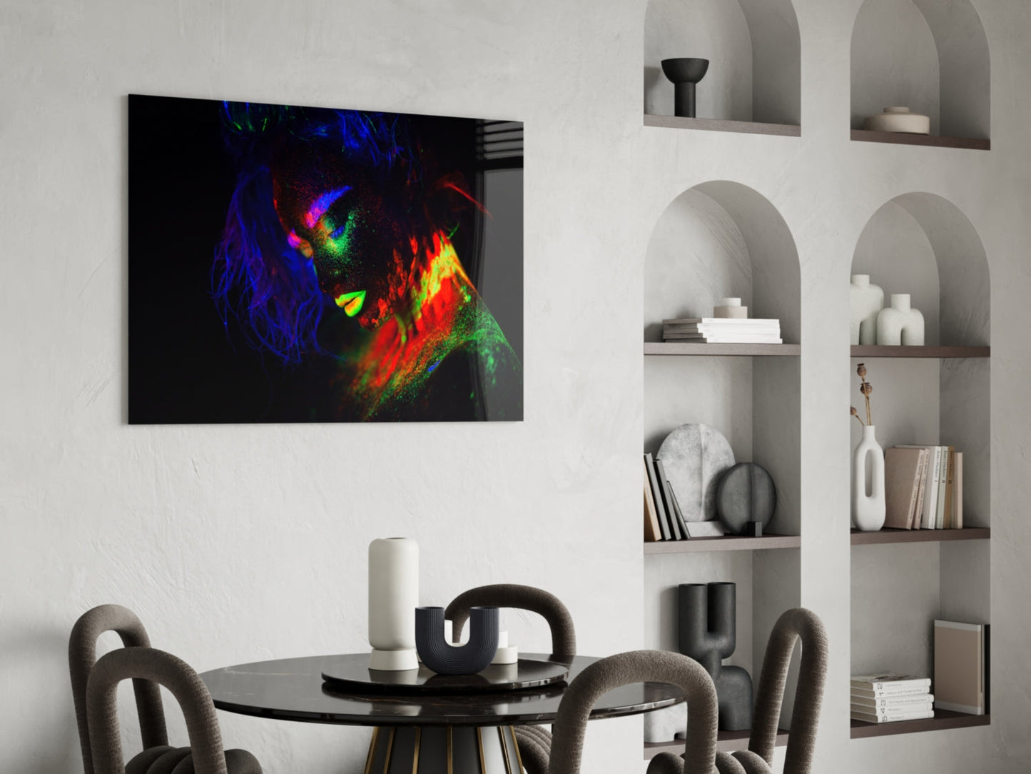 Neon-colored female portrait with vibrant blue, green, red, and yellow paint strokes displayed on glass above a black dining table in a modern interior.