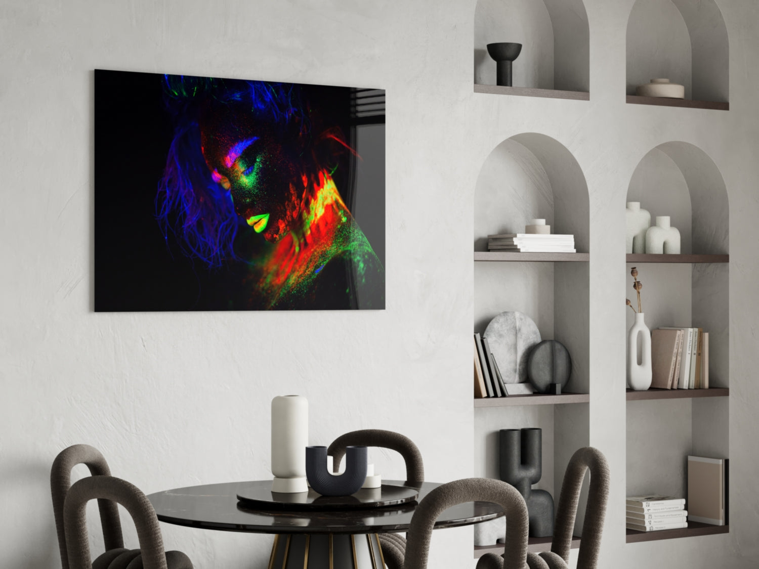 Neon-colored female portrait with vibrant blue, green, red, and yellow paint strokes displayed on glass above a black dining table in a modern interior.