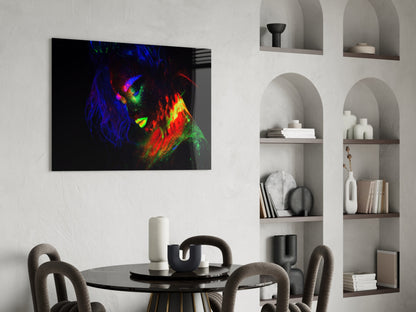 Neon-colored female portrait with vibrant blue, green, red, and yellow paint strokes displayed on glass above a black dining table in a modern interior.