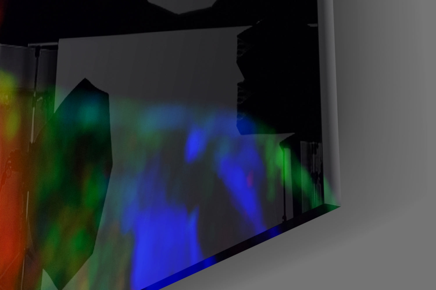 Angled view of translucent glass wall art displaying colorful light projections in blue, green, and red tones.