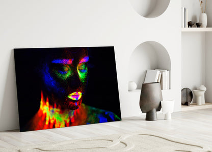 Vibrant neon portrait glass art leaning against white wall in minimalist interior setting with shelving.