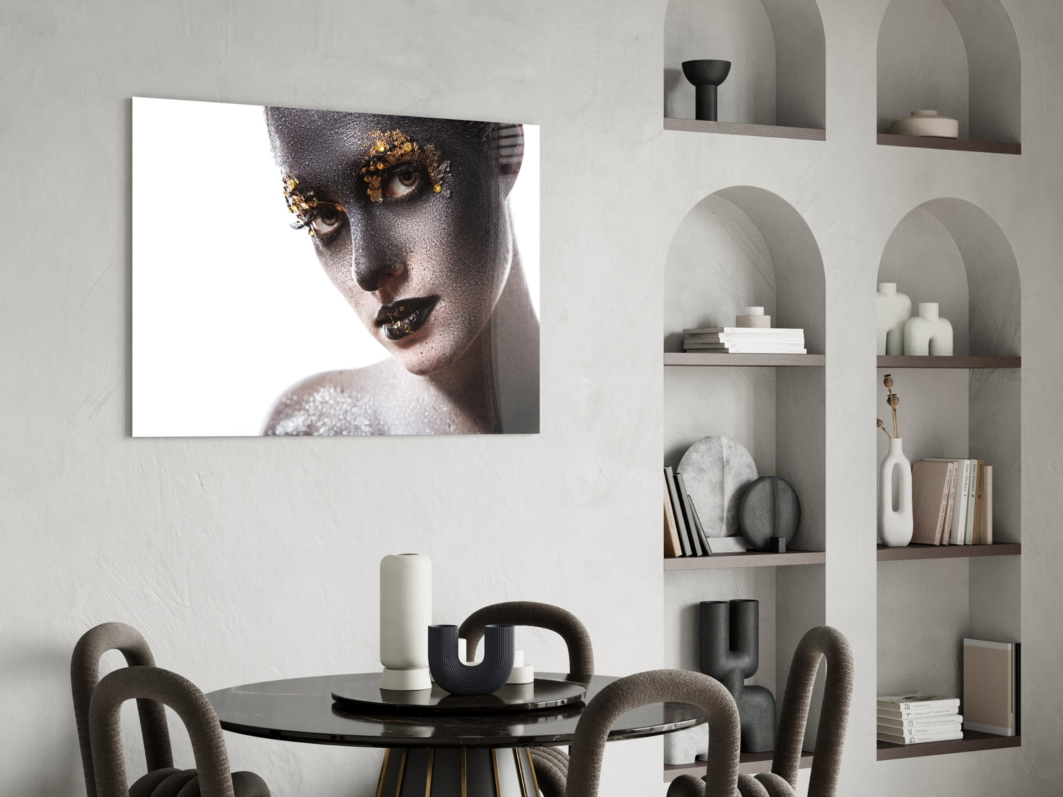 Glass wall art featuring portrait of woman with gold leaf eye makeup and silver glitter against white background, displayed above dining table.