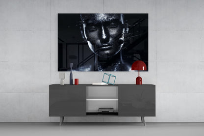 Modern living room setup with black and white female portrait glass wall art displayed above gray media console with red decorative accessories.