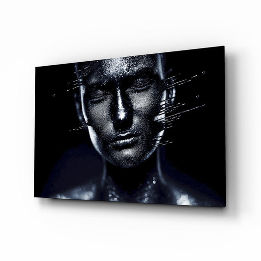 Glass wall art displaying a monochromatic portrait of a woman's face with silver sparkle effects and dark background, mounted at an angle.