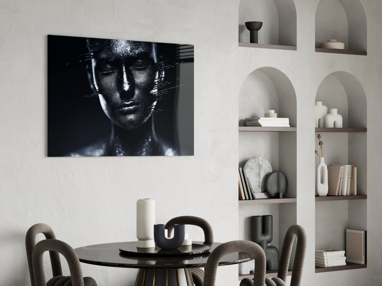 Black and white glass wall art featuring a female portrait with metallic texture, displayed above a round dining table with upholstered chairs and styled shelving.