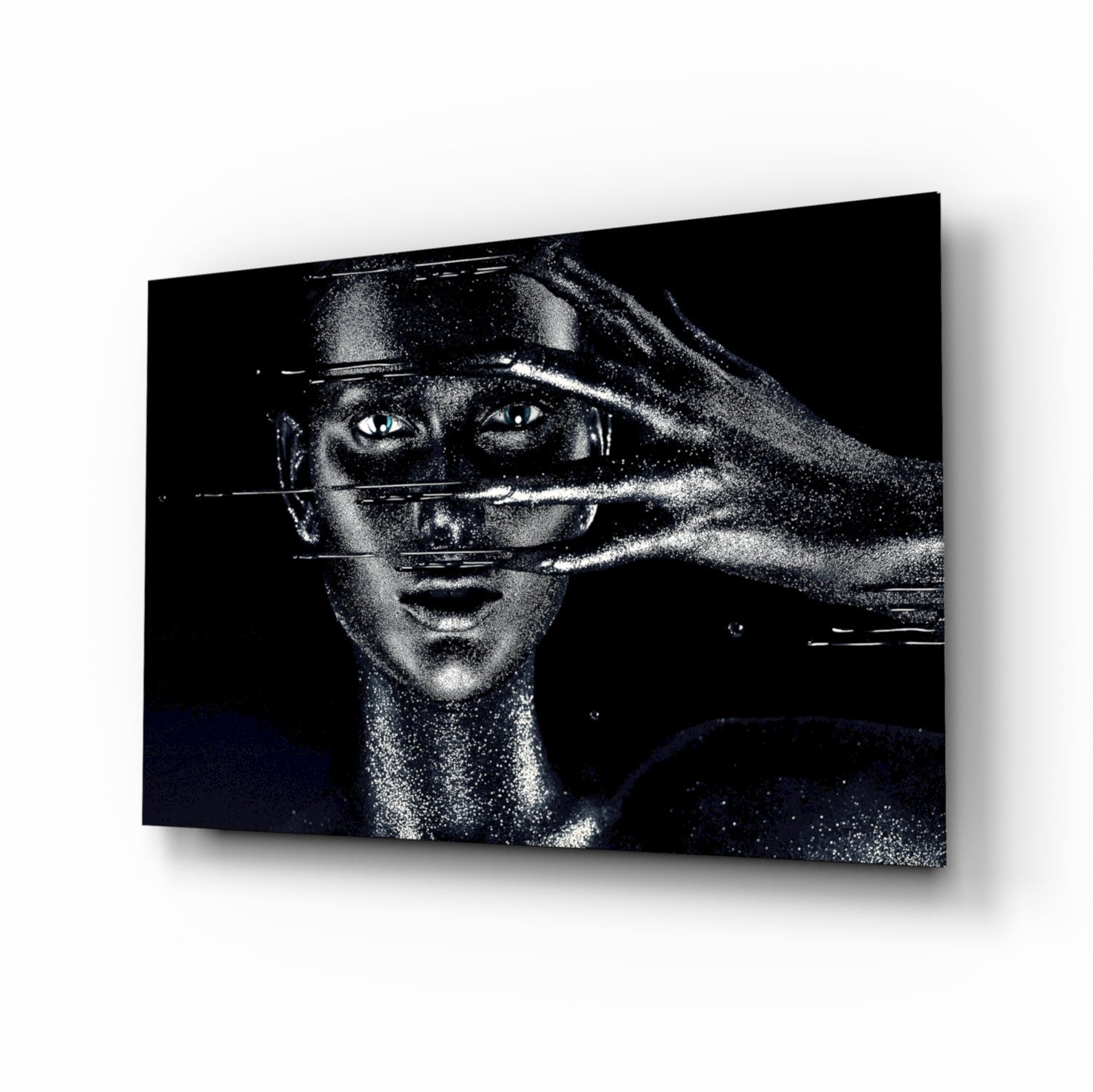 Black and white glass wall art featuring a woman's face with geometric lines crossing her eyes and face, displayed at an angle against a white background.
