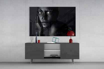 Black and white portrait of a woman displayed on glass mounted above a gray media console with red decorative accessories.