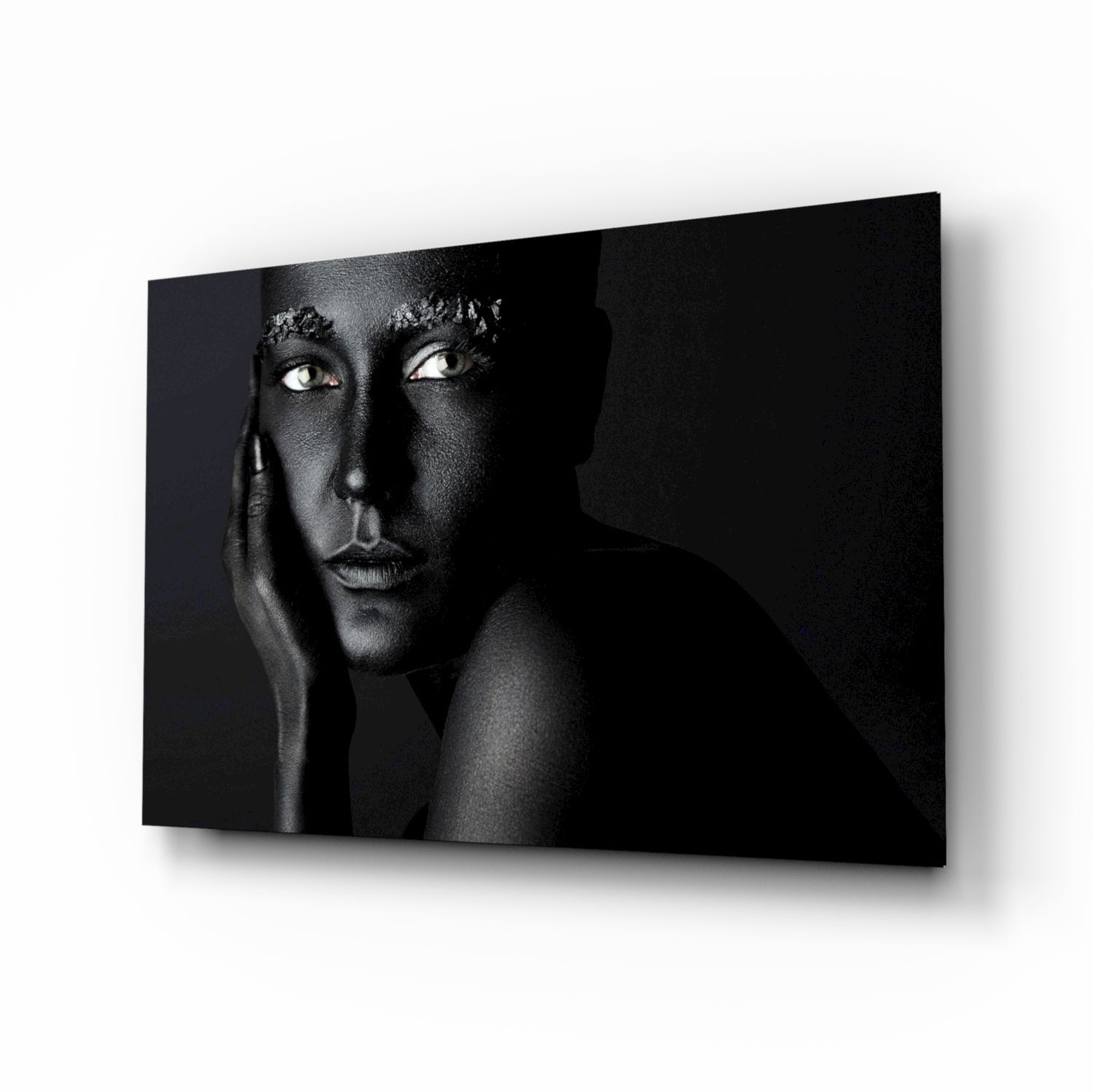 Black and white portrait of a woman on glass wall art displayed at an angle against white background.