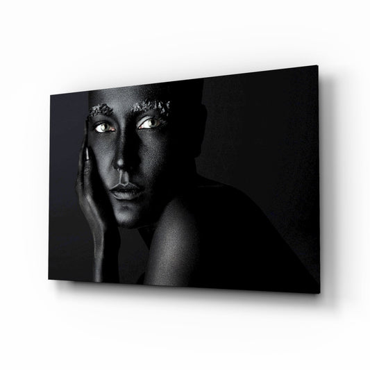 Black and white portrait of a woman on glass wall art displayed at an angle against white background.