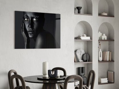 Black and white portrait of woman's face with striking eyes displayed on glass above dining table in modern interior.