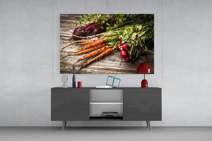 Fresh vegetables glass wall art displaying carrots, beets, and radishes on wood, mounted above gray media console in modern living room.