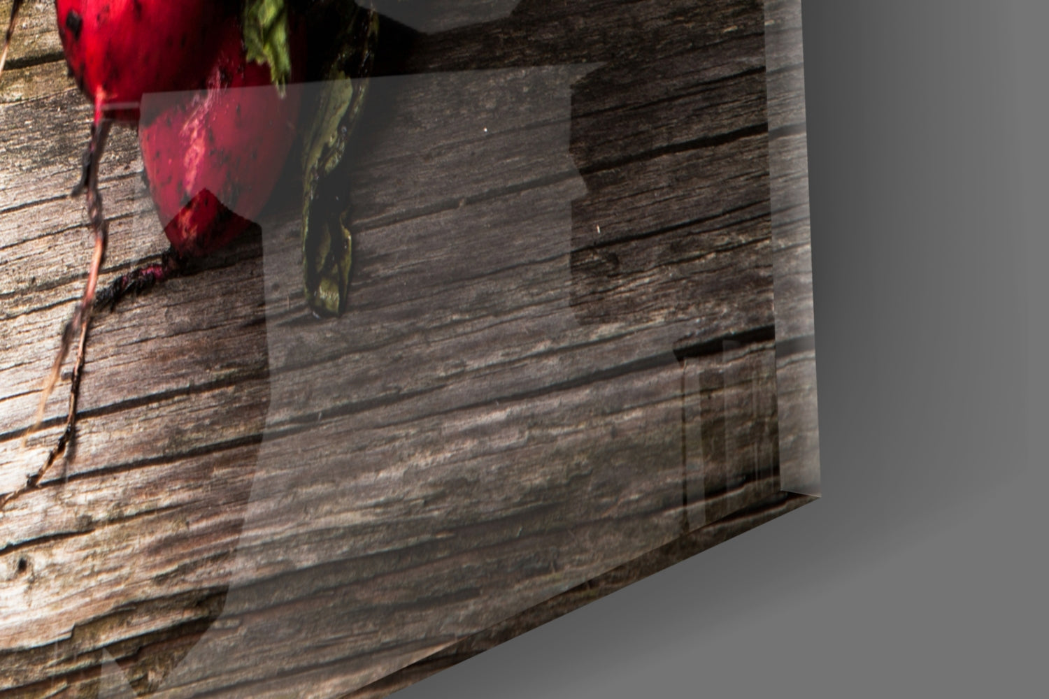 Glass wall art with red carrot and green radish designs displayed against rustic wooden plank background.