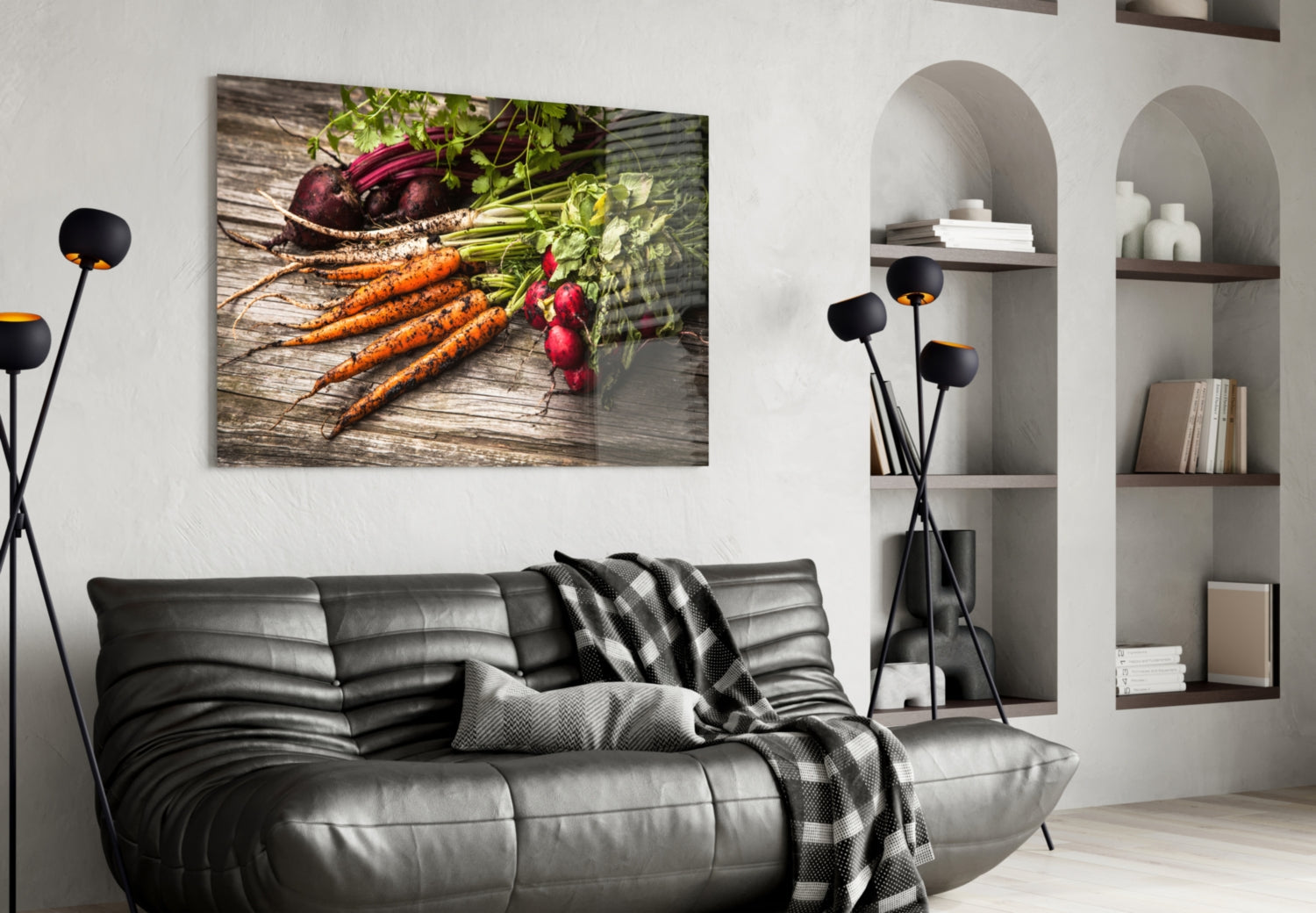 Glass wall art displaying fresh carrots and radishes on wooden surface, hung above black leather sofa in modern living room.