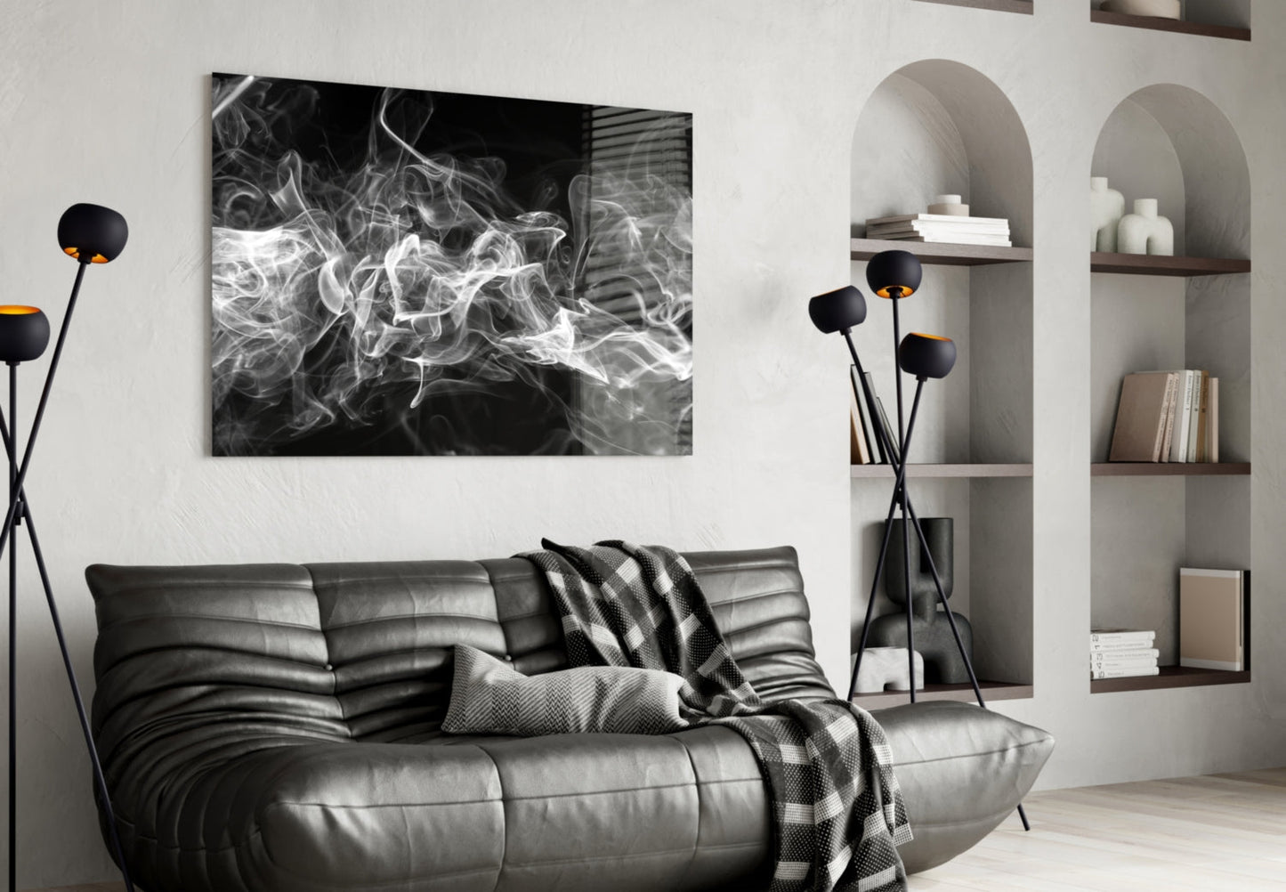 Black and white abstract smoke artwork displayed above a dark leather sofa in a modern living room setting.