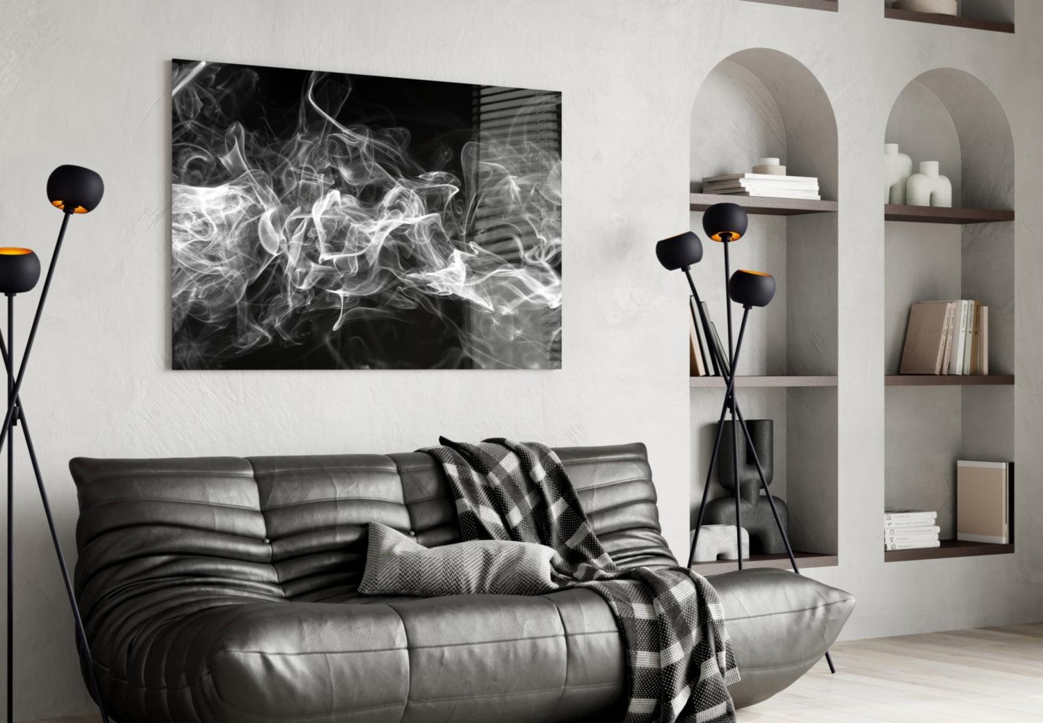 Black and white abstract smoke artwork displayed above a dark leather sofa in a modern living room setting.