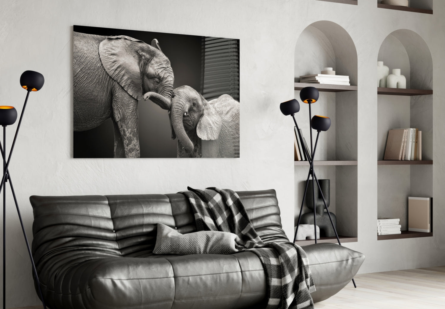 Black and white glass wall art of adult elephant with baby elephant displayed above gray leather sofa in modern living room interior.