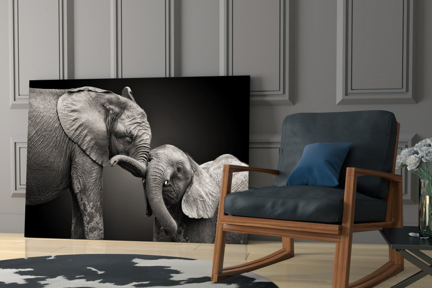Black and white glass wall art depicting adult elephant with baby elephant against dark background, displayed in modern living room setting.