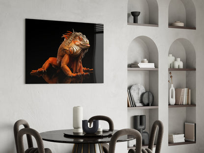 Komodo dragon glass wall art displaying an orange and tan reptile against black background, hung above a black dining table in a modern interior.