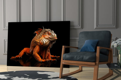 Orange and red iguana with detailed scales displayed on black glass panel in modern living room setting.
