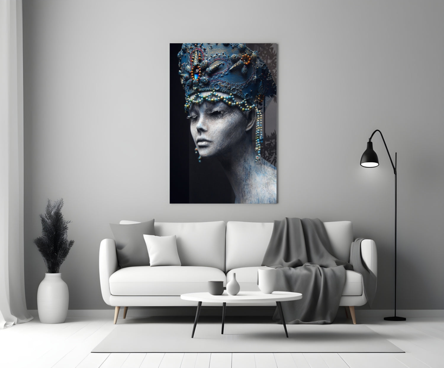 Glass wall art depicting a woman's profile with ornate blue headdress and gold beaded details against dark background, displayed above white sofa in modern living room.