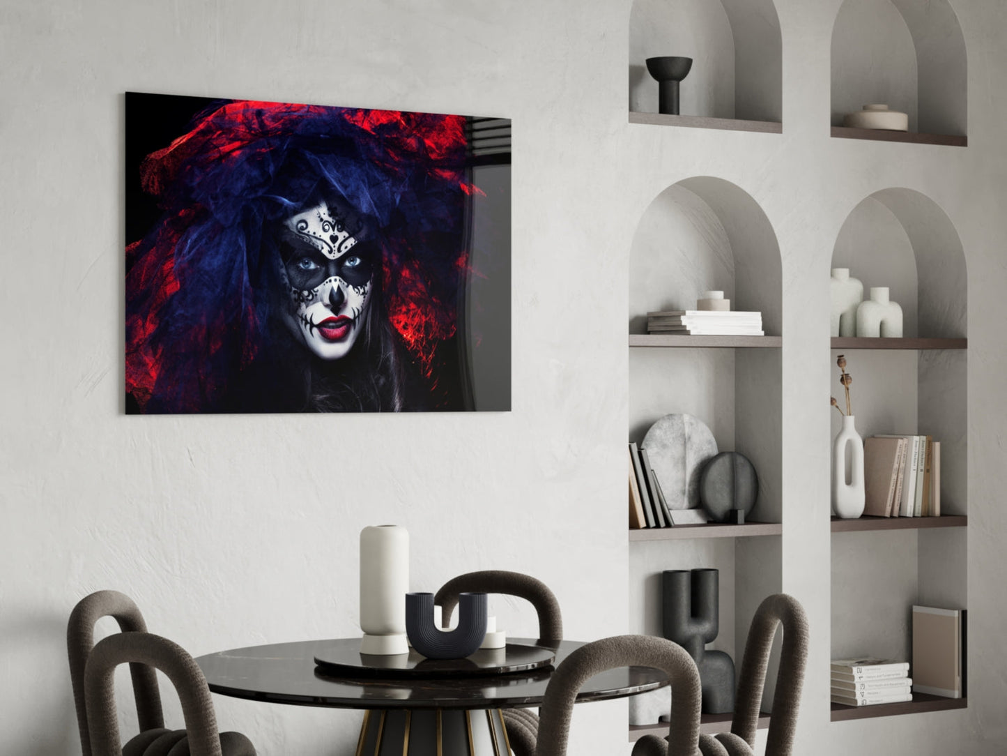 Glass wall art depicting a woman's face with dramatic makeup, red and blue hair, displayed above a round dining table in a modern interior.