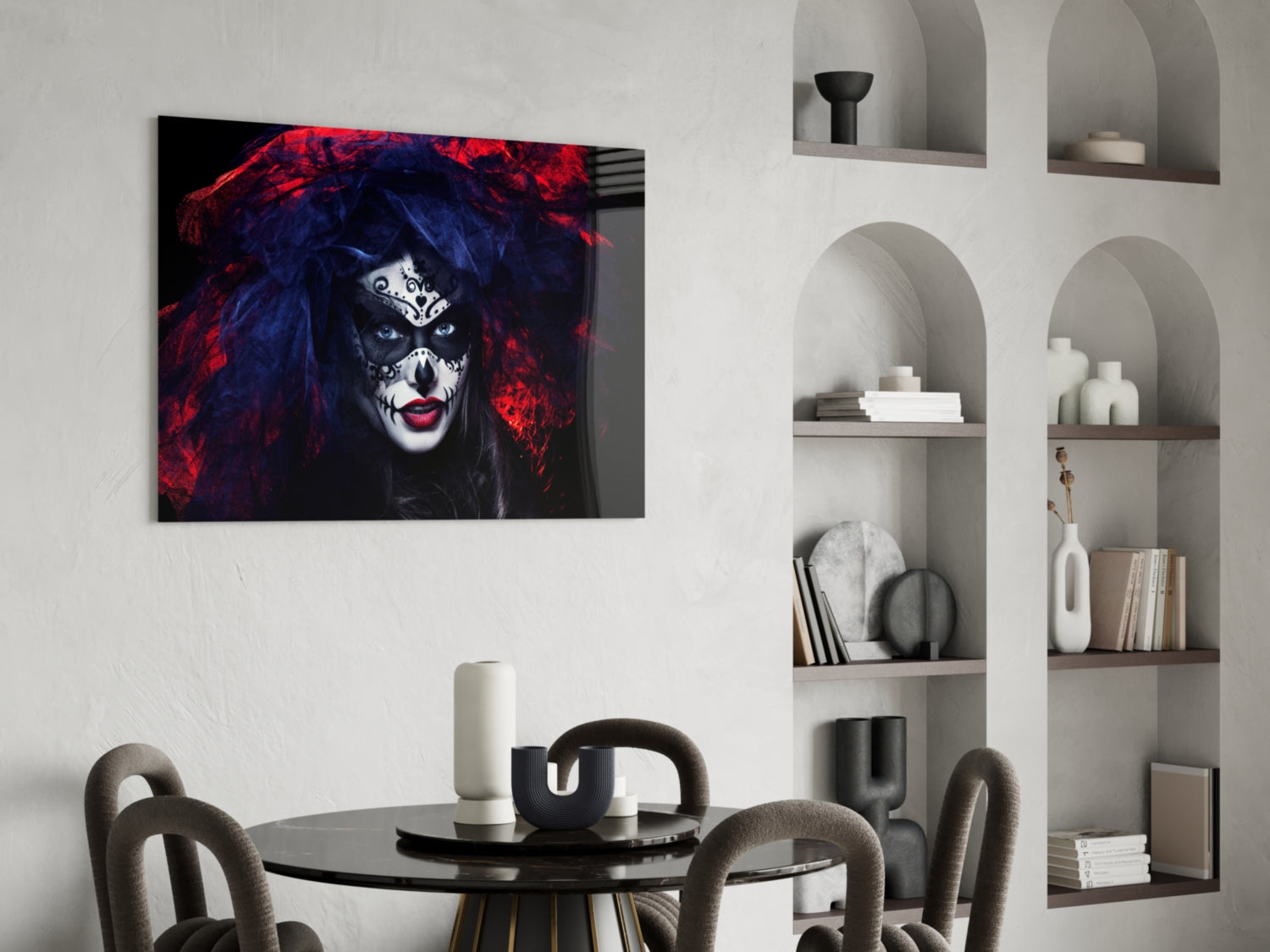 Glass wall art depicting a woman's face with dramatic makeup, red and blue hair, displayed above a round dining table in a modern interior.