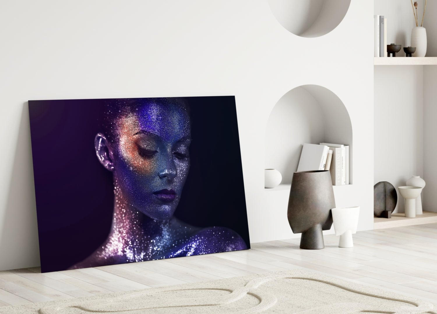 Glass wall art leaning against white wall displays profile of woman's face with purple and blue glitter effect on dark background.