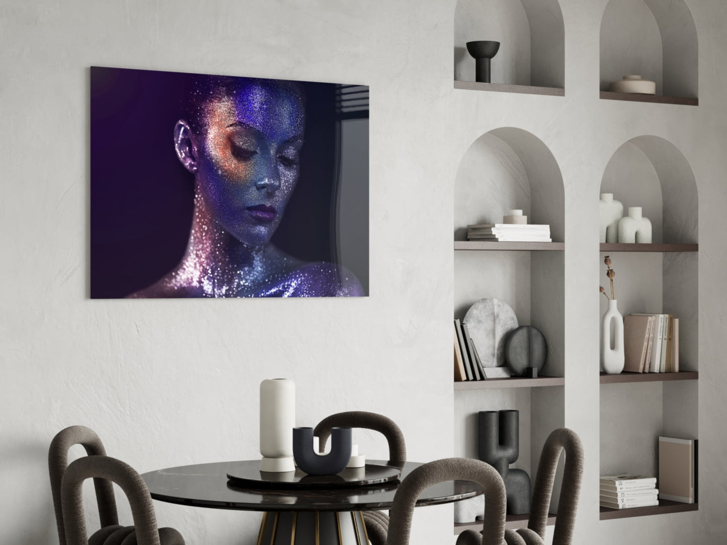 Glass wall art featuring a woman's face with blue and purple glitter effects displayed above a dining table in a modern interior.